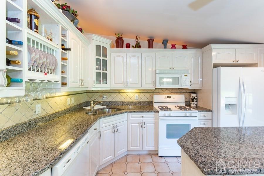 33 Southfield Road Edison, NJ 08820 - Photo 9 of 36 a kitchen with granite countertop a sink a stove and cabinets