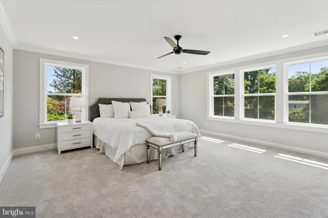 a bed sitting in a spacious bedroom next to a window