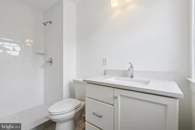 a bathroom with a granite countertop toilet sink and mirror