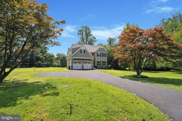 a view of a house with a big yard and large trees