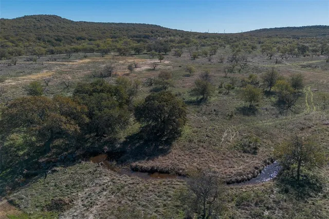 a view of a dry mountains and green field