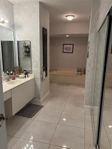 a bathroom with a double vanity sink a mirror and a bathtub