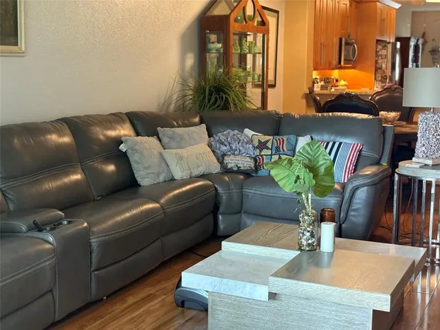 a living room with furniture flowerpot and wooden floor