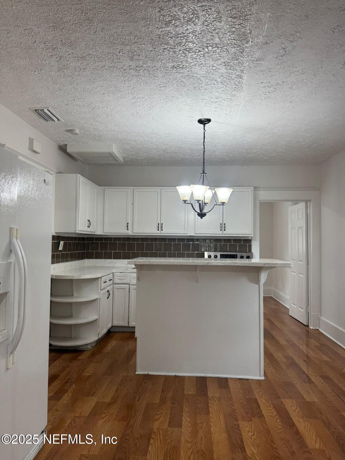 340 West 23rd Street Jacksonville, FL 32206 - Photo 5 of 13 a kitchen with kitchen island granite countertop a sink cabinets and wooden floor