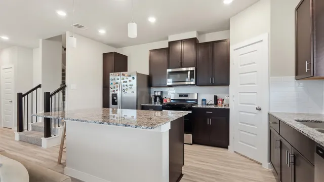 a kitchen with stainless steel appliances granite countertop a refrigerator stove microwave and sink