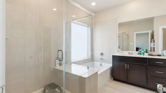 a bathroom with a sink and mirror with bathtub