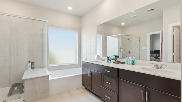 a bathroom with a double vanity sink mirror double and bathtub