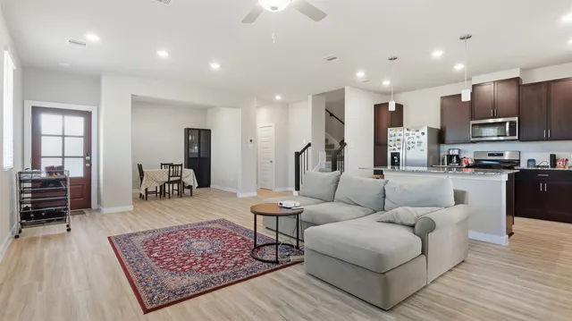 a living room with furniture and a wooden floor