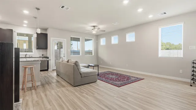 a living room with furniture and a wooden floor
