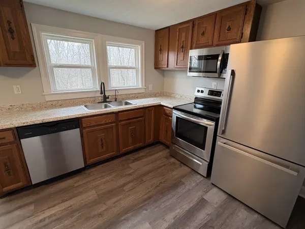 a kitchen with stainless steel appliances granite countertop a stove a sink dishwasher a refrigerator and a microwave