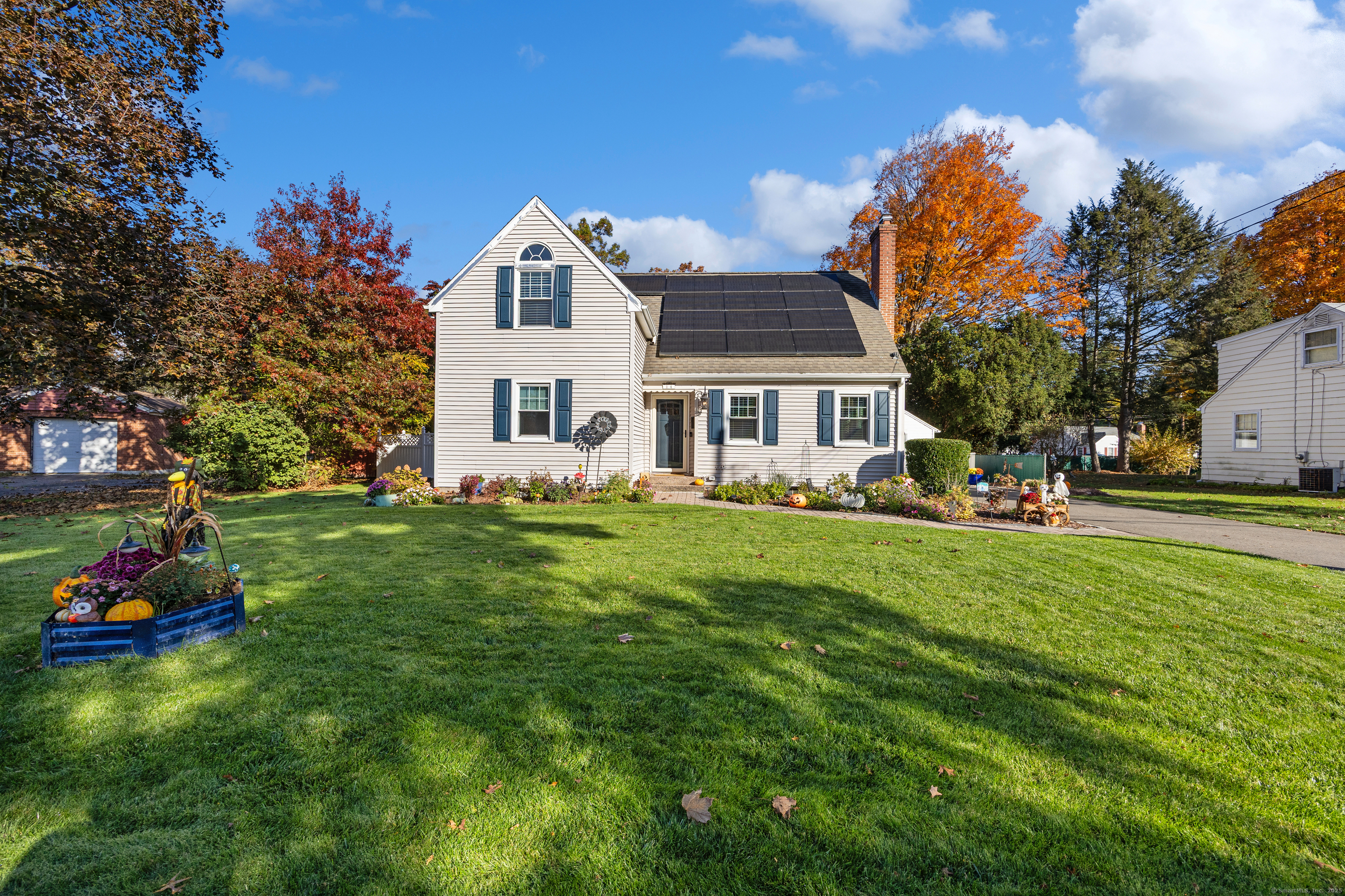 a front view of a house with a garden and trees