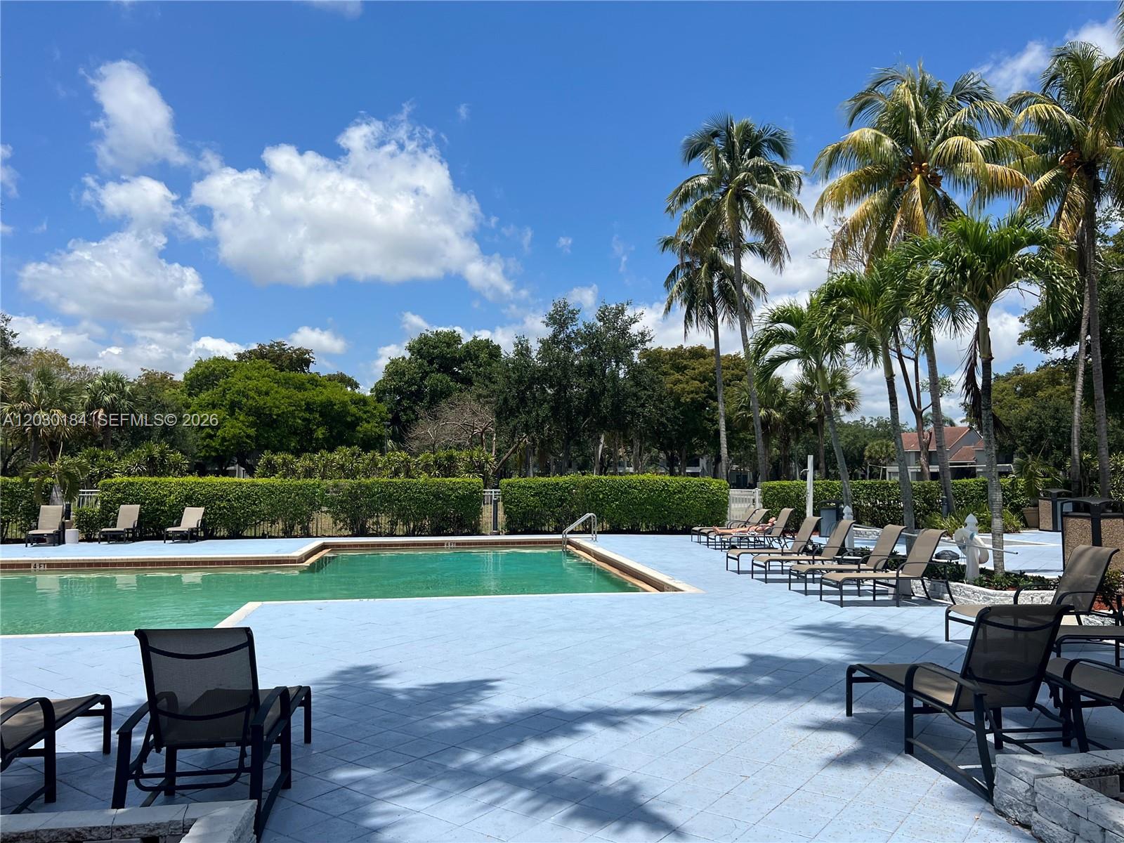 951 Lyons Road, Unit 6104 Coconut Creek, FL 33063 - Photo 14 of 18 a view of a chairs and table in a yard