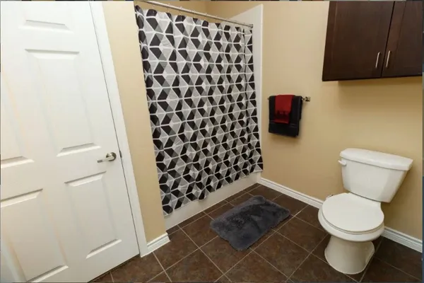 a bathroom with a granite countertop sink toilet and mirror