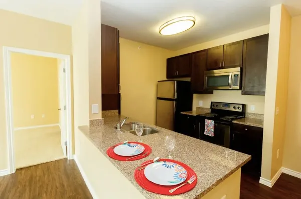 a kitchen with stainless steel appliances wooden cabinets and a refrigerator