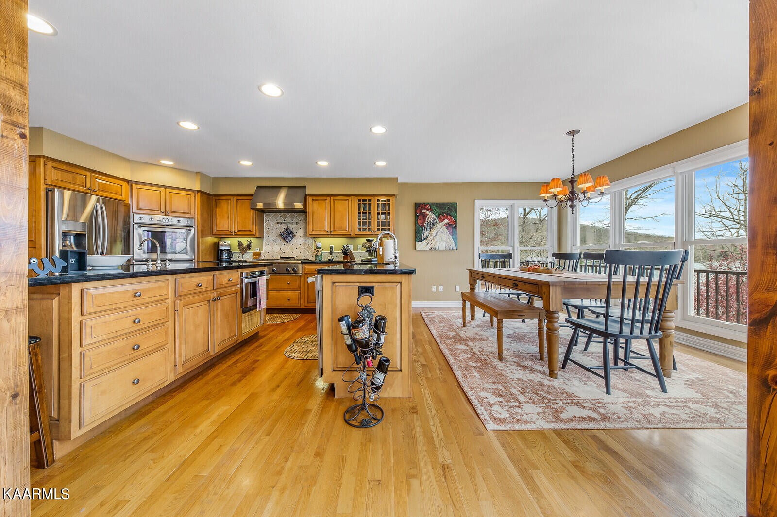 16 Milnor Circle Crossville, TN 38558 - Photo 14 of 50 a kitchen with stainless steel appliances granite countertop a stove top oven a dining table and chairs with wooden floor