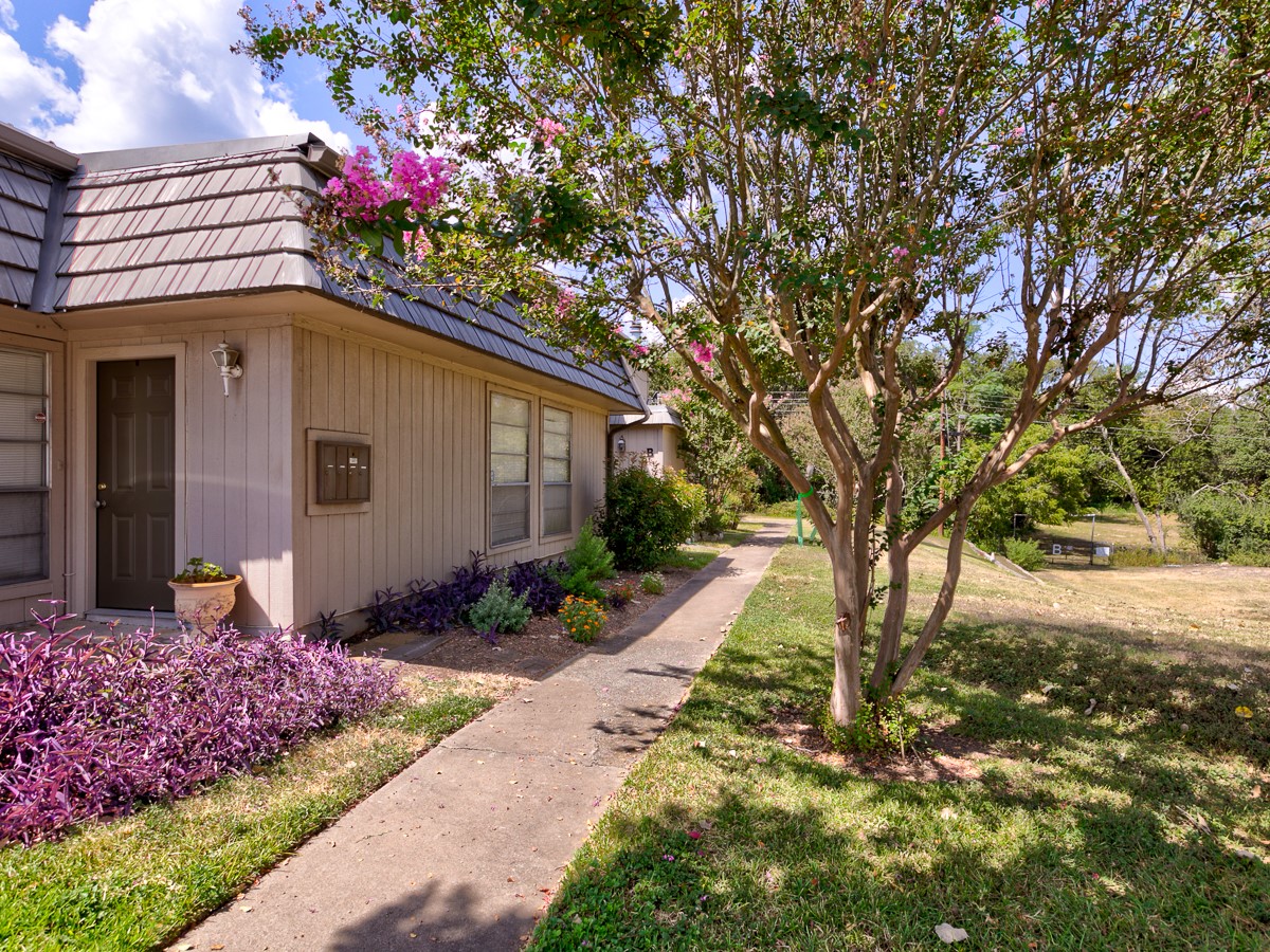 710 Castle Ridge Road, Unit B Austin, TX 78746 - Photo 3 of 27 A welcoming front entrance with mature landscaping creates inviting curb appeal.