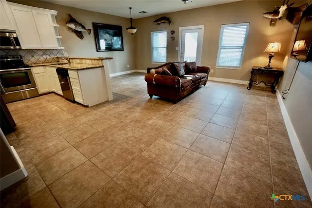 a kitchen with stainless steel appliances granite countertop a refrigerator a stove a sink and a microwave