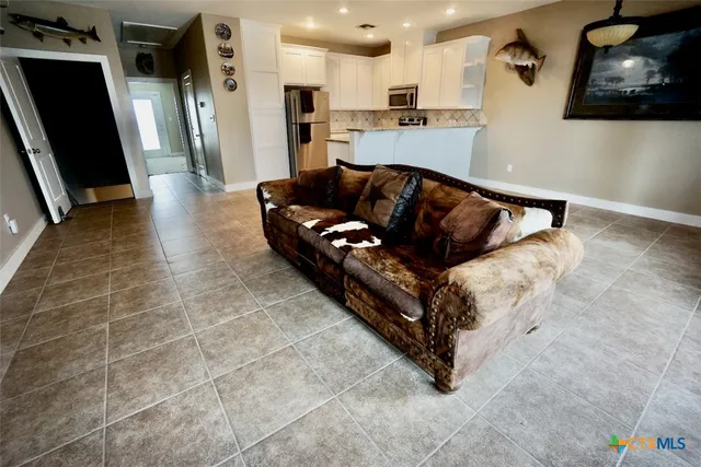 a view of a hallway with wooden floor and chairs