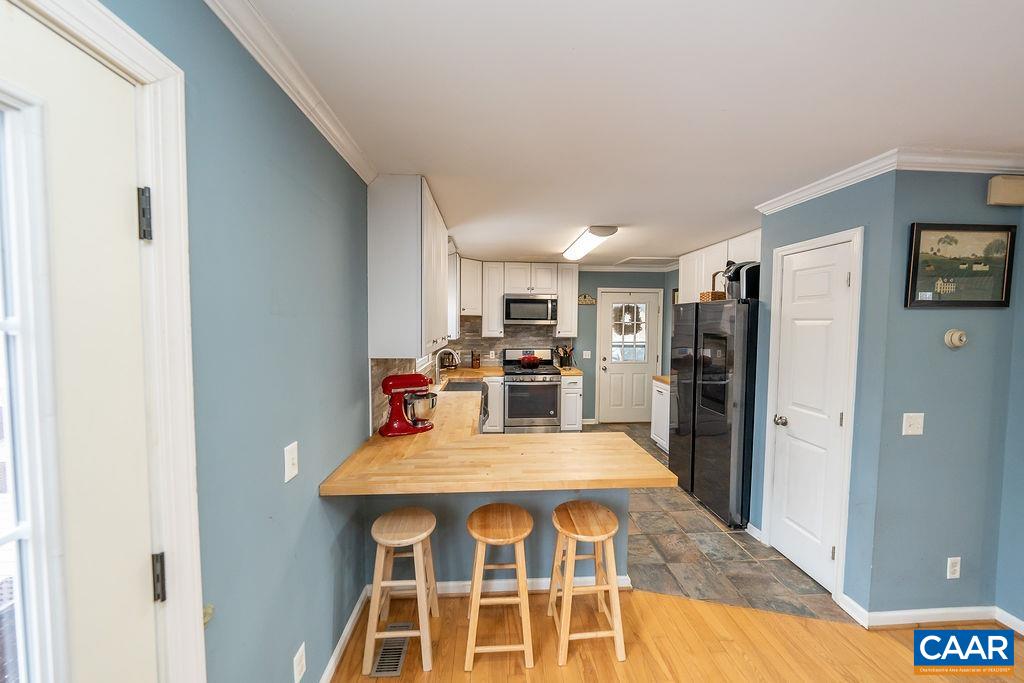 1425 Jacks Shop Road Rochelle, VA 22738 - Photo 4 of 66 a view of a kitchen with dining area refrigerator and wooden floor