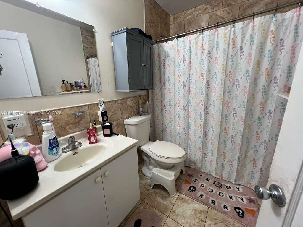 1130 Rutland Street Opa-Locka, FL 33054 - Photo 19 of 49 a bathroom with a sink a toilet and shower curtain