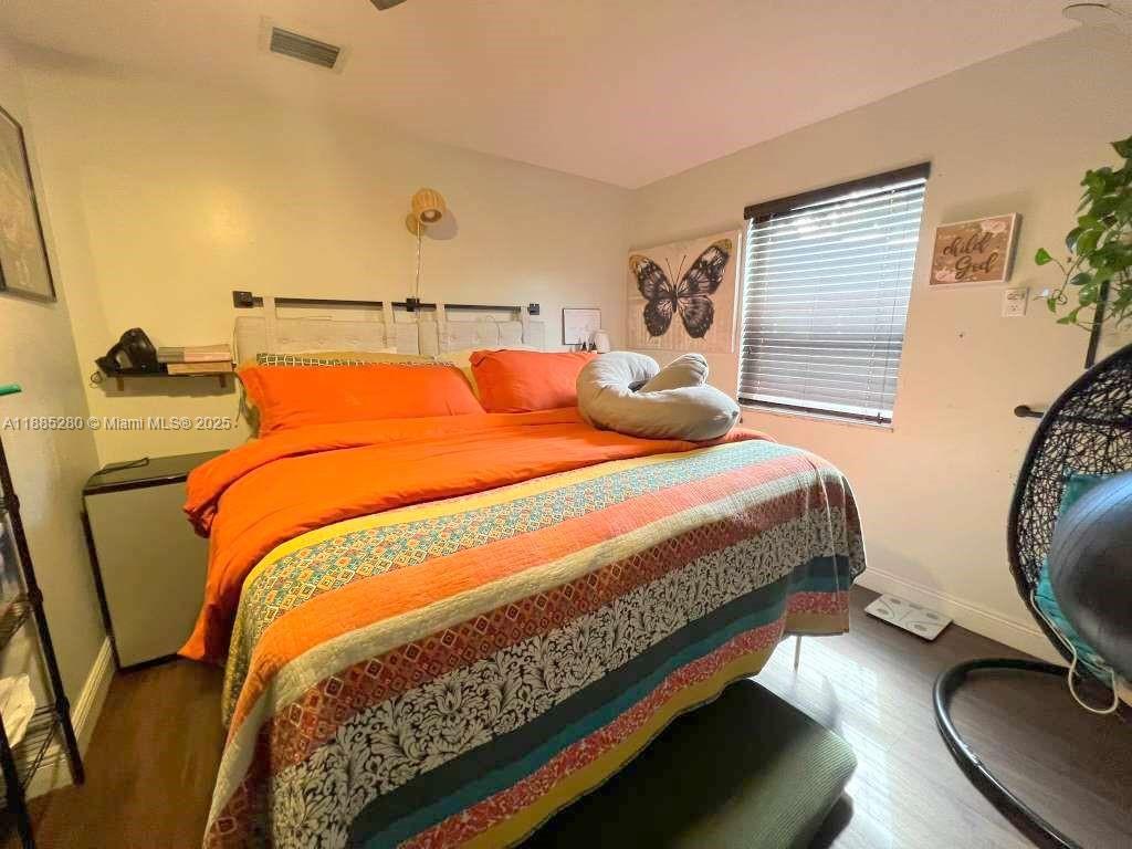 1130 Rutland Street Opa-Locka, FL 33054 - Photo 21 of 49 a bedroom with a bed and wooden floor