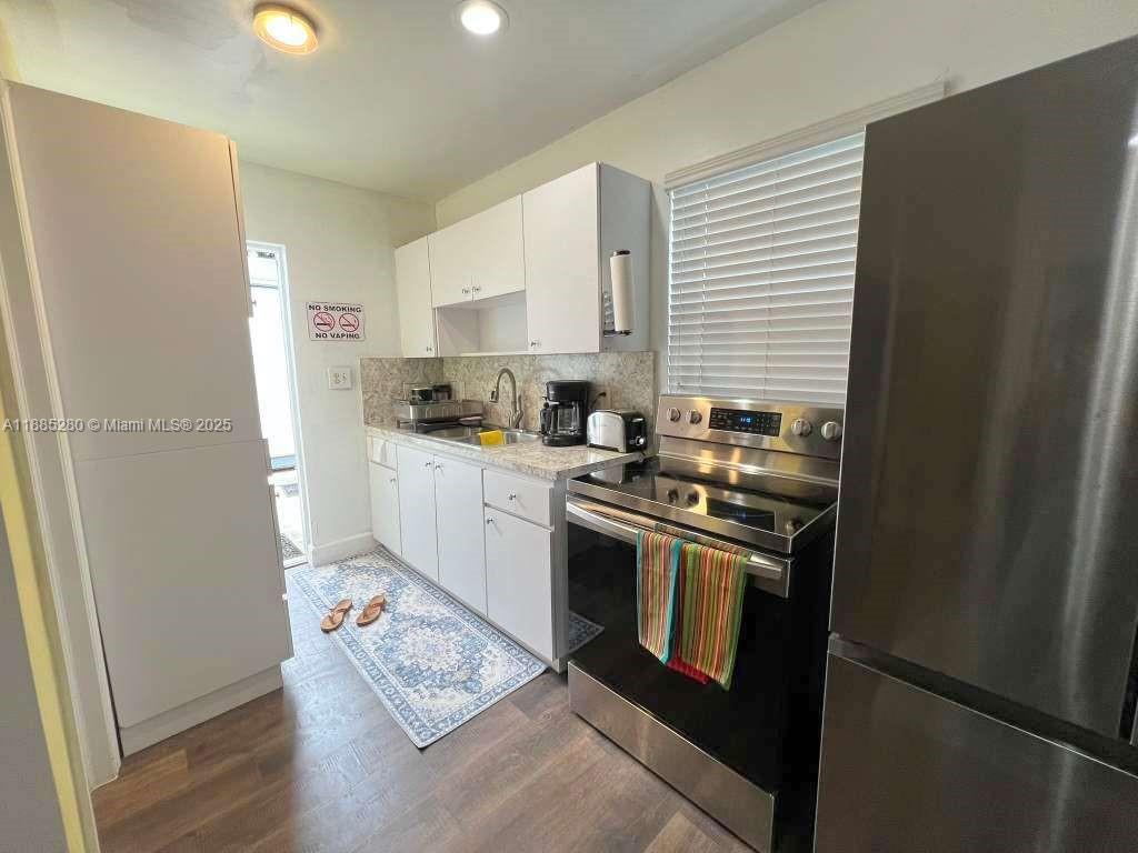 1130 Rutland Street Opa-Locka, FL 33054 - Photo 37 of 49 a kitchen with stainless steel appliances granite countertop a refrigerator a stove a sink and a microwave