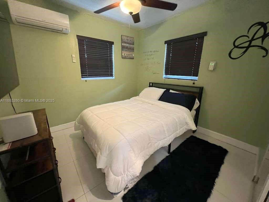 1130 Rutland Street Opa-Locka, FL 33054 - Photo 39 of 49 a bedroom with a bed and a chandelier