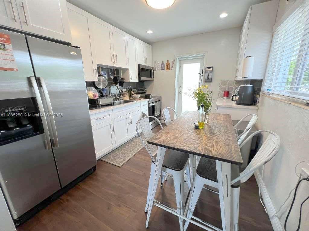 1130 Rutland Street Opa-Locka, FL 33054 - Photo 9 of 49 a kitchen with stainless steel appliances a dining table chairs refrigerator and sink