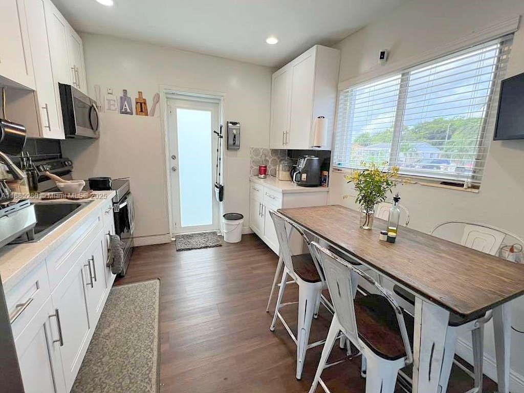 1130 Rutland Street Opa-Locka, FL 33054 - Photo 10 of 49 a kitchen with stainless steel appliances a table and chairs in it