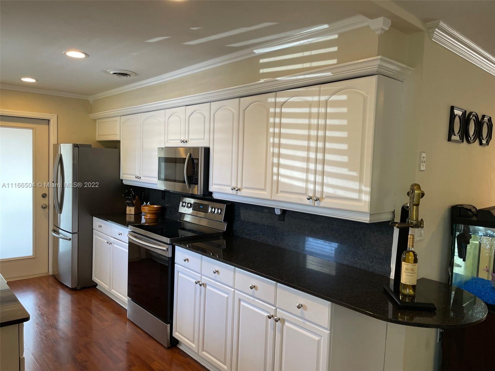 400 Southwest 14th Place Boca Raton, FL 33432 - Photo 6 of 29 a kitchen with granite countertop white cabinets and stainless steel appliances