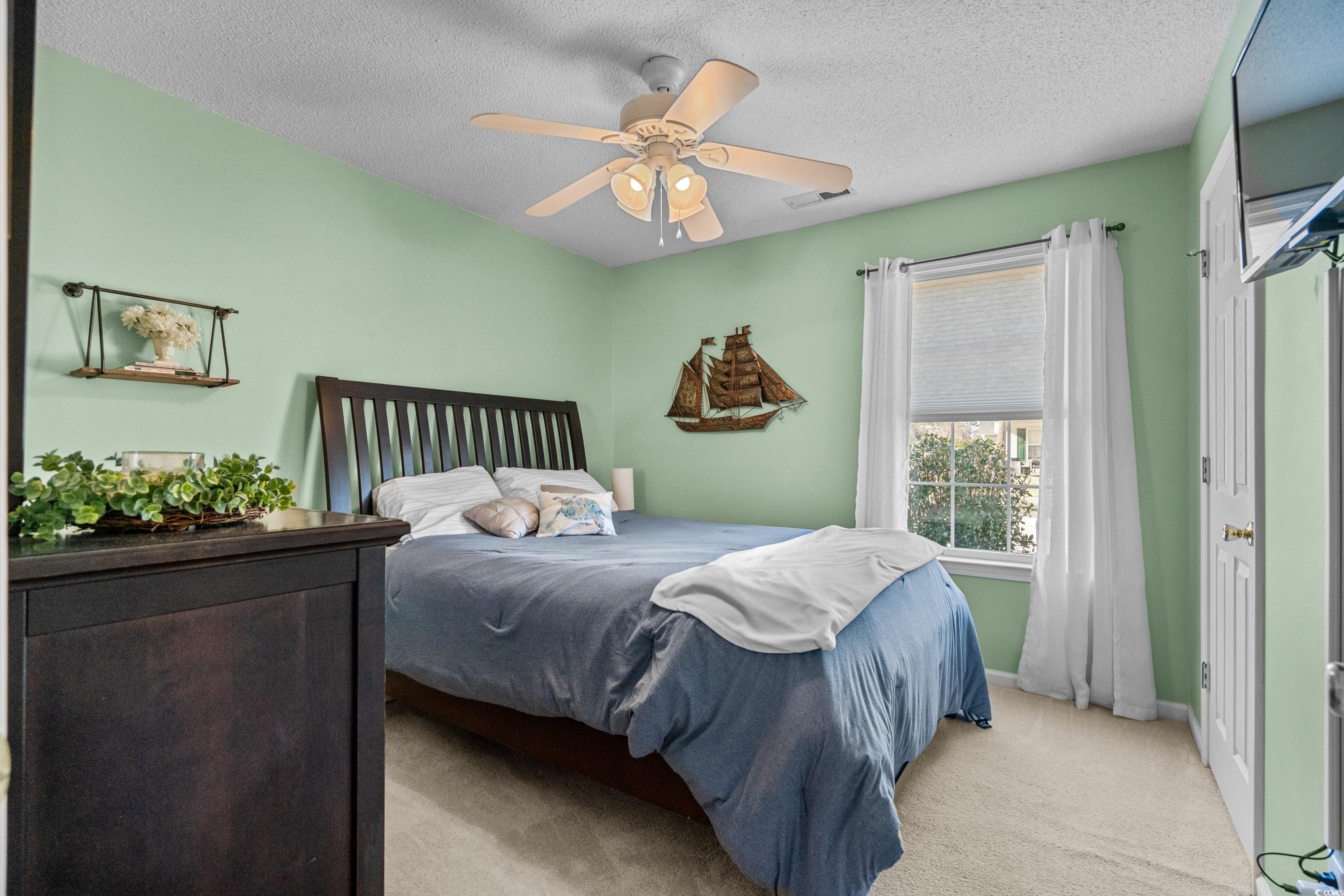 300 Kildare Court Myrtle Beach, SC 29588 - Photo 16 of 26 Carpeted bedroom featuring ceiling fan and a textu