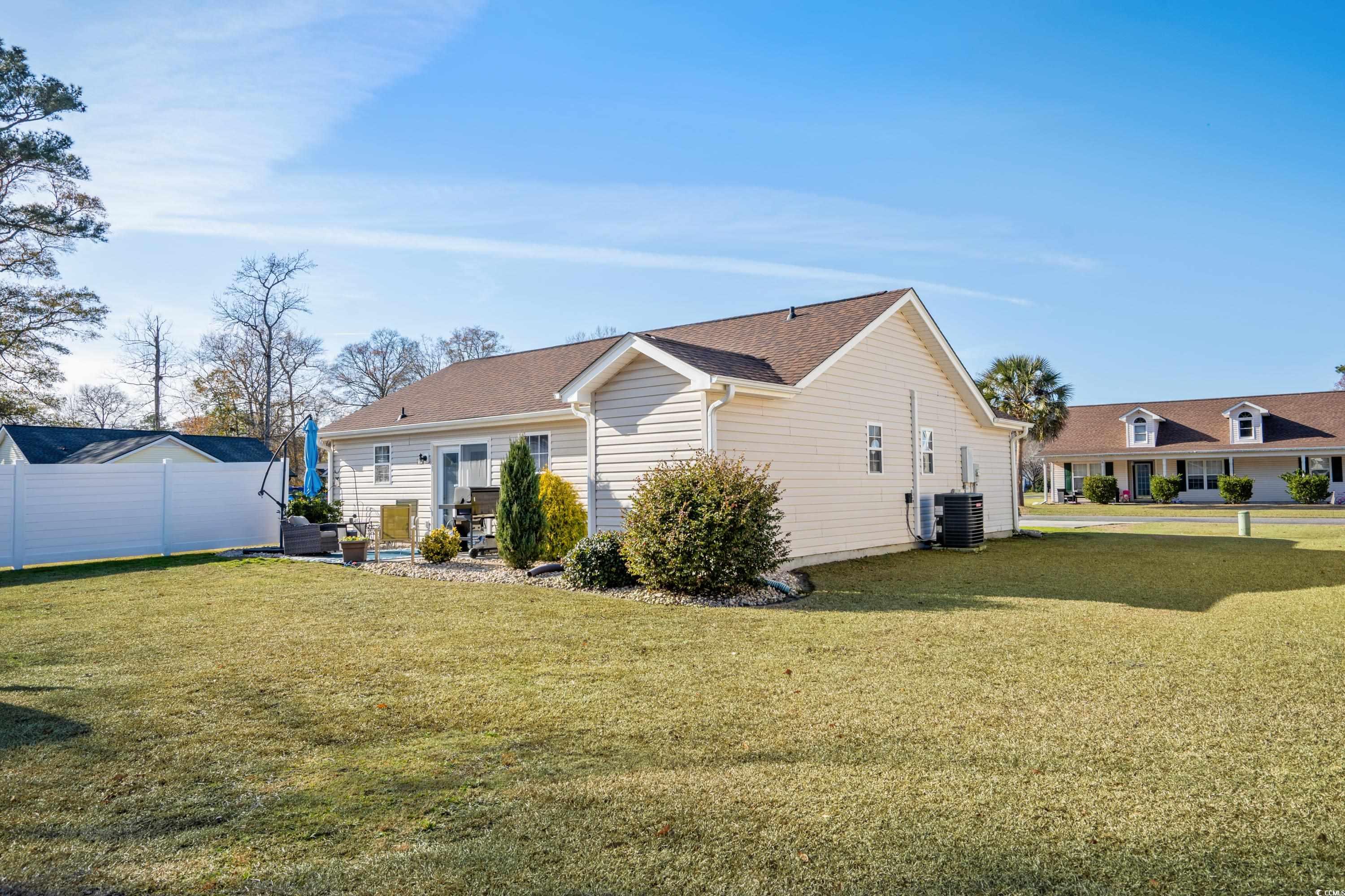 300 Kildare Court Myrtle Beach, SC 29588 - Photo 22 of 26 Back of house featuring a lawn and central air con