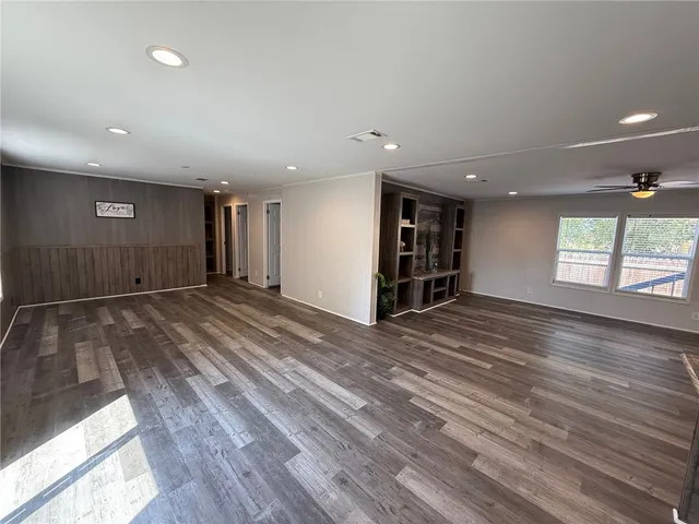 an empty room with wooden floor and window