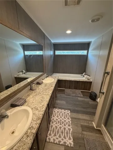 a bathroom with a granite countertop double vanity sink and a mirror