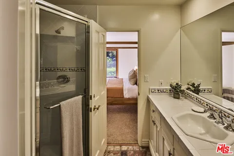 a en suite bathroom with a sink a mirror and a shower