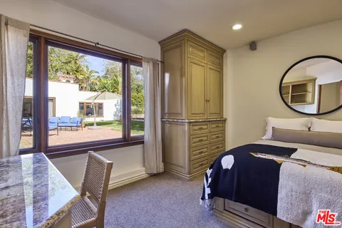 a bedroom with a bed lamp and a large window