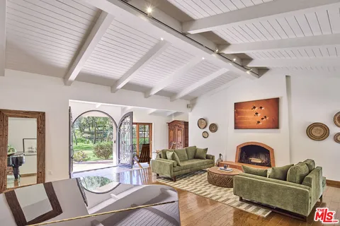 a living room with furniture a fireplace and a large window