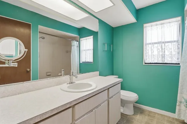 a bathroom with a toilet sink and mirror
