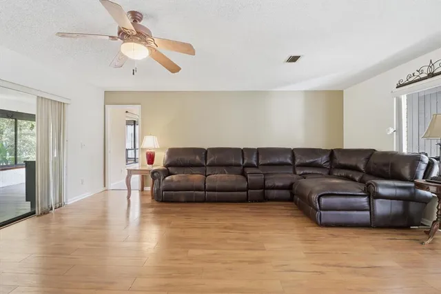 a living room with furniture and a ceiling fan