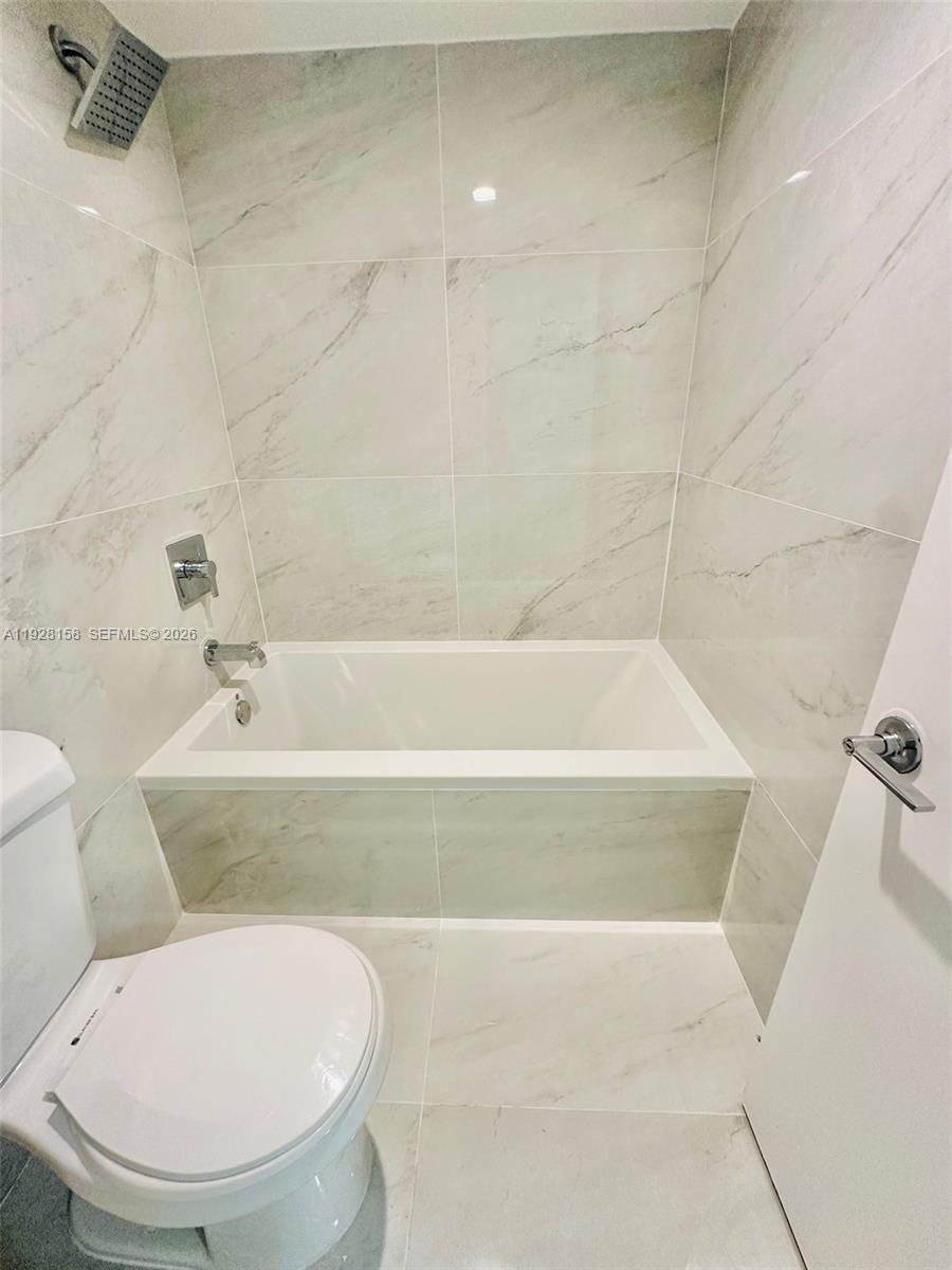 9273 Collins Avenue, Unit 207 Surfside, FL 33154 - Photo 5 of 14 a bathroom with a toilet and a bathtub