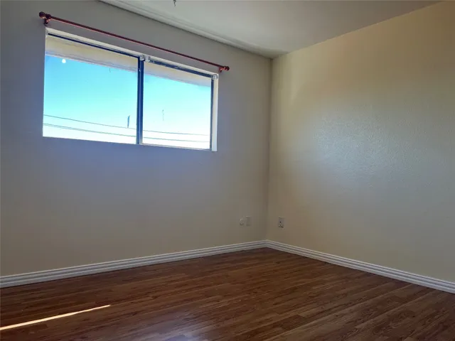 a view of a small space with wooden floor and a window