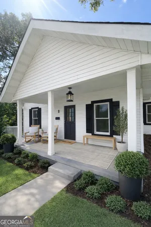 a front view of a house with garden and plants