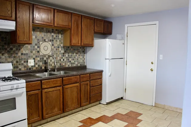 a kitchen with stainless steel appliances granite countertop a refrigerator and a stove top oven