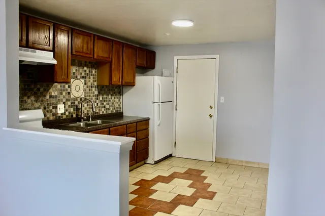 a kitchen with stainless steel appliances granite countertop a refrigerator and a stove top oven