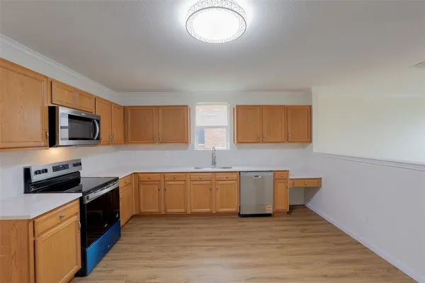 a kitchen with stainless steel appliances granite countertop a stove a sink and a microwave