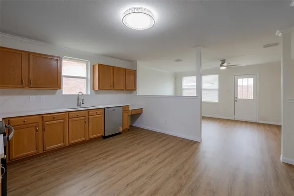 a large kitchen with wooden floors and white cabinets