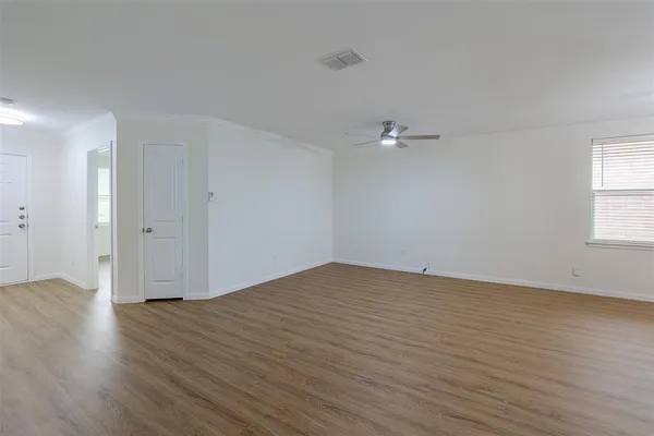 a view of an empty room with wooden floor