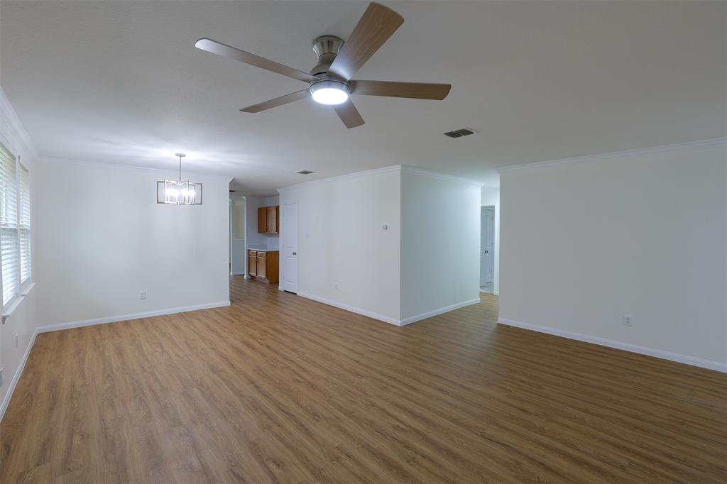 8422 Seven Hills Road Arlington, TX 76002 - Photo 8 of 28 a view of an empty room with wooden floor and a ceiling fan