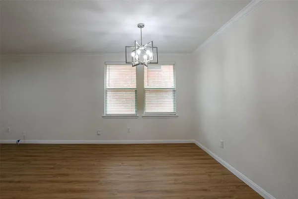 a view of a room with wooden floor chandelier and window