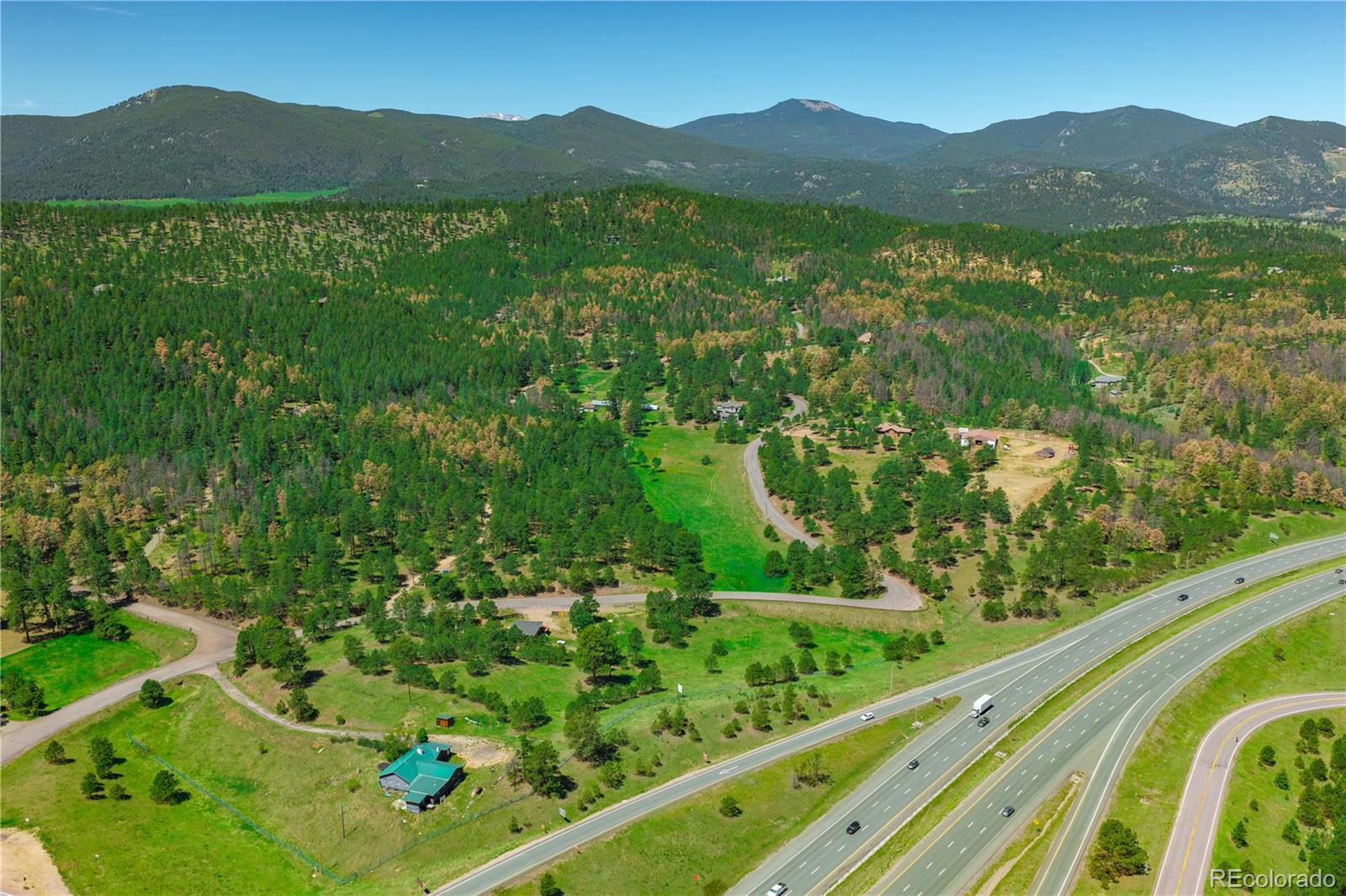 29793 Ruby Ranch Road Evergreen, CO 80439 - Photo 4 of 28 a view of a lush green field with a mountain in the background